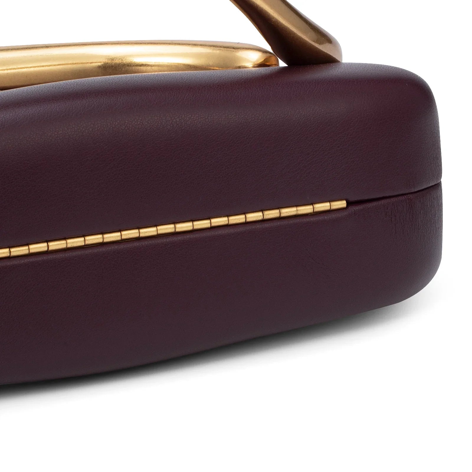Close-up of a purple handbag with gold accents on a white background