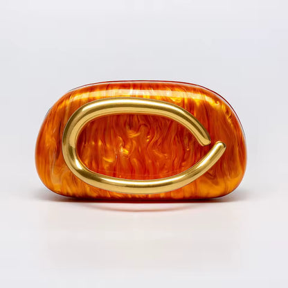 Orange flame-patterned clutch with gold handle on a light gray background