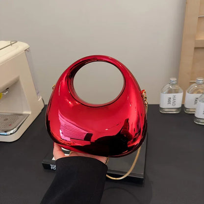 Red handbag held by a person with a neutral background