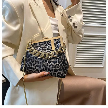 Person holding a leopard print handbag with gold chain detail