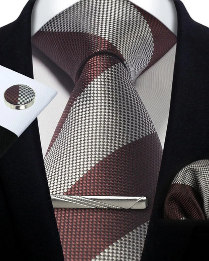 Patterned tie with matching pocket square and cufflinks on a mannequin.