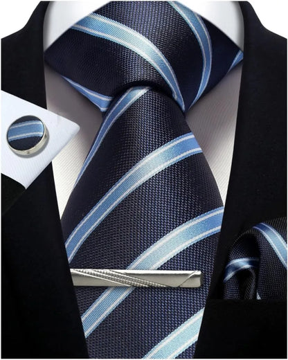 Navy and light blue striped tie with matching cufflinks and tie clip on a black suit jacket.