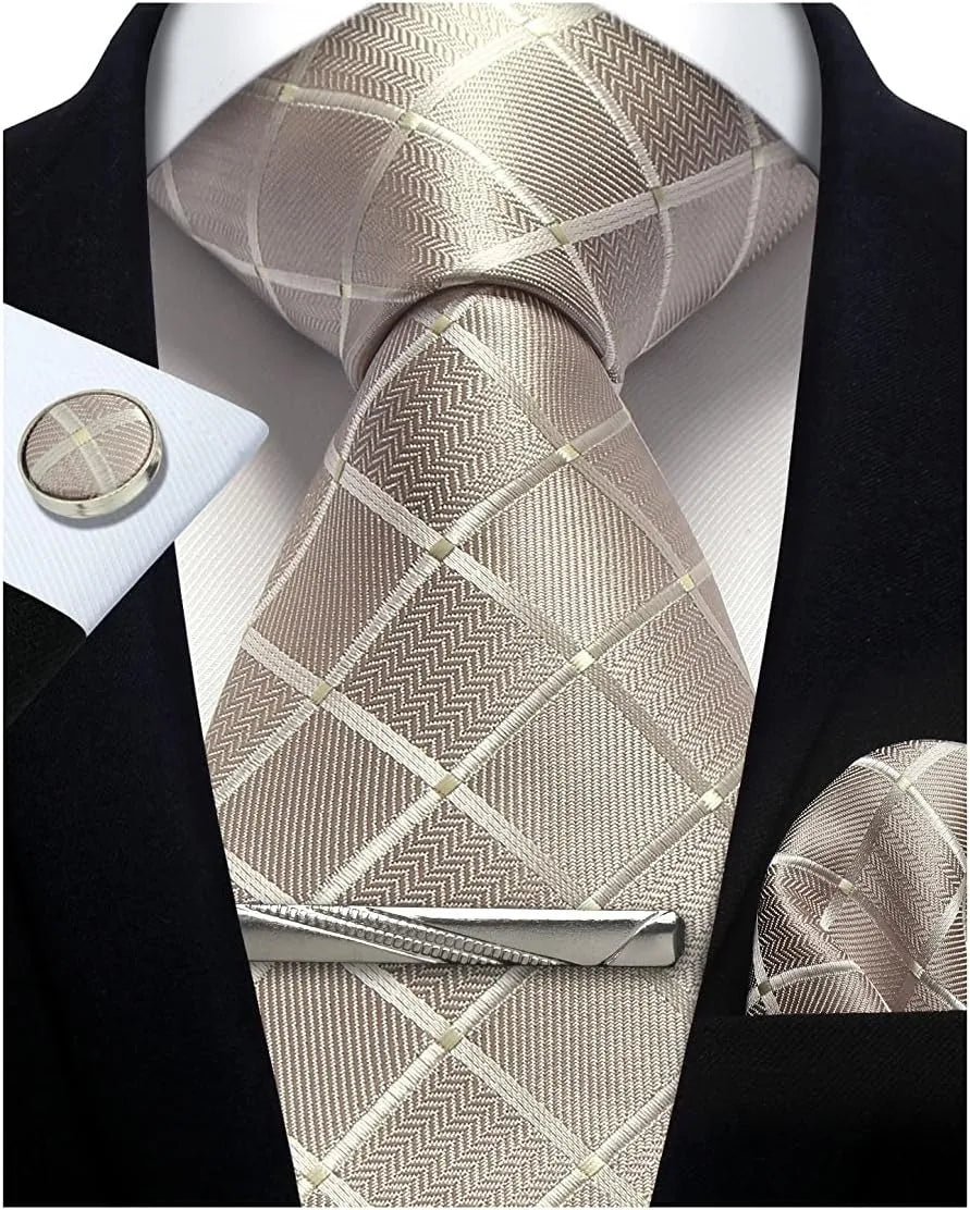 Silver patterned tie with matching cufflinks and pocket square on a black suit.