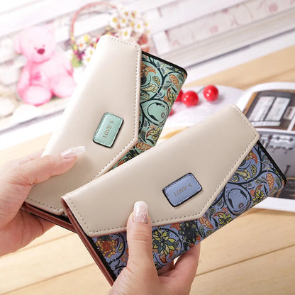Two wallets with floral patterns held by a hand